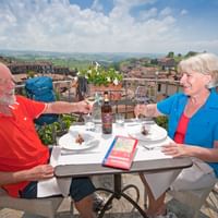Couple trinquant sur une charmante terrasse ave une vue magnifique
