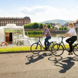 Deux cyclistes se promènent au bord du port fluvial de Saverne en Alsace
