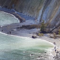 Falaises de craie du parc national Jasmund Vue aérienne des falaises de craie blanches du parc national Jasmund sur l'île de Rügen avec des visiteurs sur la plage et l'eau turquoise.