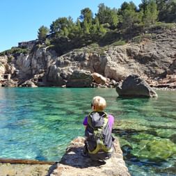 Randonneuse prend une pause dans la magnifique baie de Deia, à Majorque