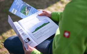 Randonneuse étudiant un topoguide et une carte IGN