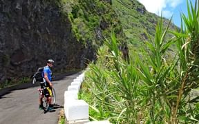 Cycliste grimpant une côte dans les environs de Porto Moniz, Madère
