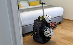 Valise étiquetée et casques à vélo dans une chambre d'hôtel