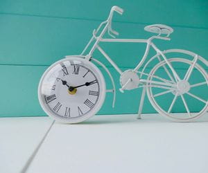 Maquette de vélo avec une horloge au centre de sa roue avant 