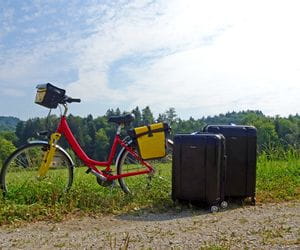 Deux valises posées à côté d'un vélo de randonnée 
