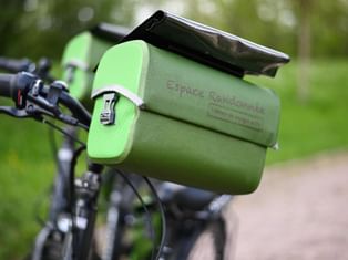 Sacoche de guidon verte Espace Randonnée montée sur guidon de vélo avec support smartphone au-dessus, sur sentier forestier.