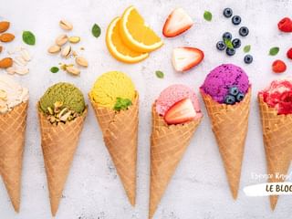 Six cornets de glaces colorés alignés avec leurs fruits
