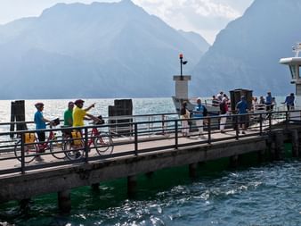 Cyclotouristes sur un ponton sur le Lac de Garde pendant leurs vacances à vélo en Italie