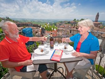 Couple trinquant sur une charmante terrasse ave une vue magnifique