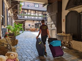 Notre collaborateur Julien transporte les valises de clients dans un hôtel d'Obernai en ALsace