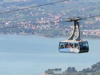 Cabine de téléphérique suspendue au-dessus du lac de Constance avec vue panoramique sur le lac, les collines et villes depuis le Pfänder.