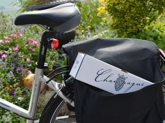Vélo contenant dans sa sacoche, une bouteille de Champagne emballée