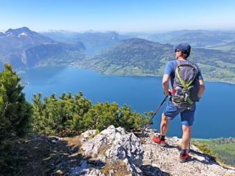 Randonneur admire la vue depuis les hauteurs du lac Attersee