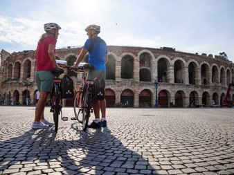 Couple de cyclotouristes devant les arènes de Vérone