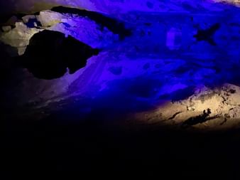 Grotte de sel souterraine éclairée d'un éclairage bleu dramatique, montrant des formations de sel blanc et des parois rocheuses au Salzkammergut.