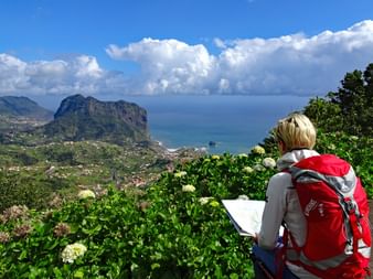 Randonneuse devant un panorama spectaculaire sur la côte de Madère, Porto da Cruz