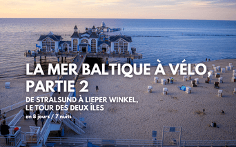 Plage de sable de la mer Baltique avec chaises de plage à capuchon blanc et jetée historique s'étendant dans l'eau au coucher du soleil.