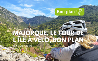 Cycliste avec casque blanc admirant vallée verte avec village et montagnes à Majorque. Texte 'Bon plan' circuit vélo.