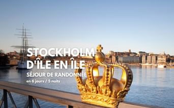 Couronne suédoise dorée sur garde-corps de pont avec paysage urbain de Stockholm, voilier historique et bâtiments riverains.