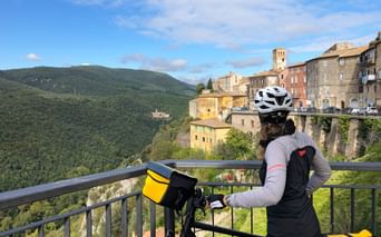 Cyclotouriste admirant le panorama depuis le viaduc de Spoleto