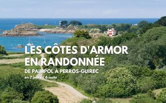 Vue panoramique de l'île de Bréhat avec eaux turquoise, côte rocheuse, phare, bateaux ancrés dans la baie et végétation luxuriante.