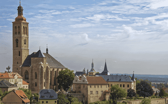 L'église Saint-Jacques avec son haut clocher domine l'horizon historique de Kutná Hora, République tchèque, avec des bâtiments aux toits rouges.