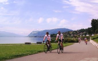 Cyclistes pédalant sur une piste cyclable longeant le Lac Léman