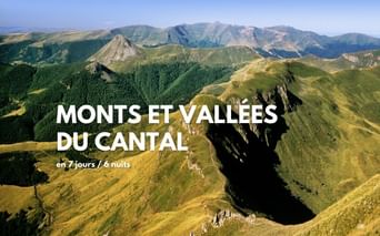 Vue aérienne des montagnes volcaniques vertes et vallées du Cantal depuis le Puy Mary, montrant des collines sous un ciel bleu.