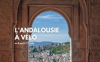 Vue sur un village blanc andalous depuis un arc maure