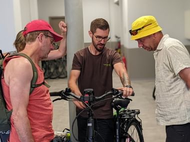Notre collaborateur Julien remet les vélos de location à un groupe de clients s'apprêtant à débuter leur circuit en Alsace
