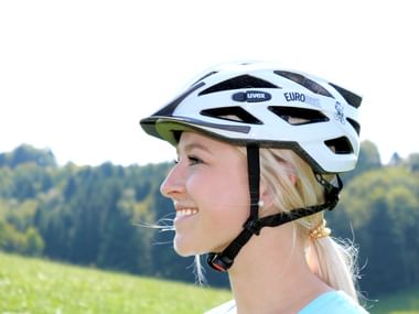 Jeune femme posant pour montrer le bon ajustement d'un casque vélo