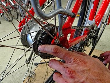 Gros plan sur une main réparant un dérailleur de vélo