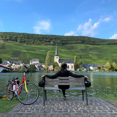La Moselle à vélo, cyclotouriste se reposant sur un banc sur les rives de la Moselle