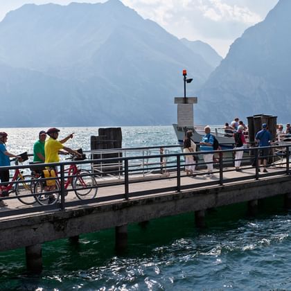 Cyclotouristes sur un ponton sur le Lac de Garde pendant leurs vacances à vélo en Italie