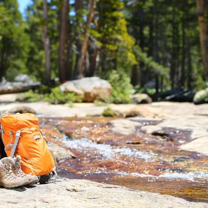 Sacs et chaussures de randonnée au bord d'un ruisseau de montagne