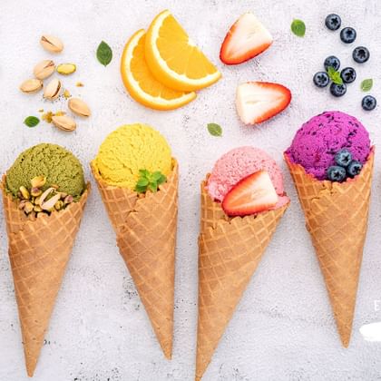 Six cornets de glaces colorés alignés avec leurs fruits