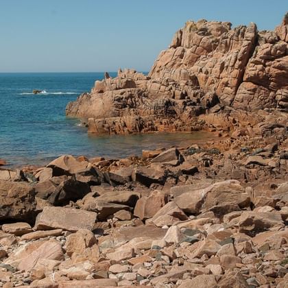 Formations rocheuses spectaculaires de granit rose sur le littoral de Ploumanac'h avec eaux océaniques bleues dans les Côtes-d'Armor.