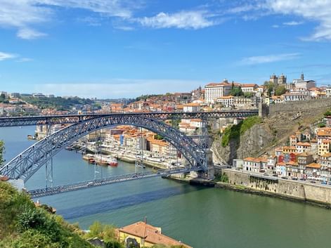 Pont Dom Luis I enjambant le Douro à Porto Vue panoramique du pont Dom Luis I de Porto, pont en arc de fer à deux niveaux traversant le Douro avec bâtiments colorés sur les collines.