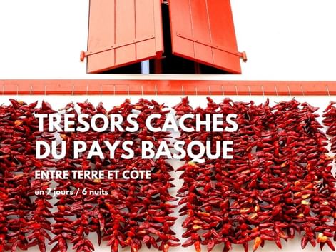 Trésors cachés du Pays Basque, un séjour à vélo clé en main. Vue d'une façade typique du village d'Espelette.
