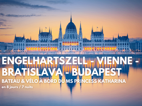 Parlement hongrois à Budapest illuminé au coucher du soleil, reflété dans le Danube avec un ciel rose et bleu.