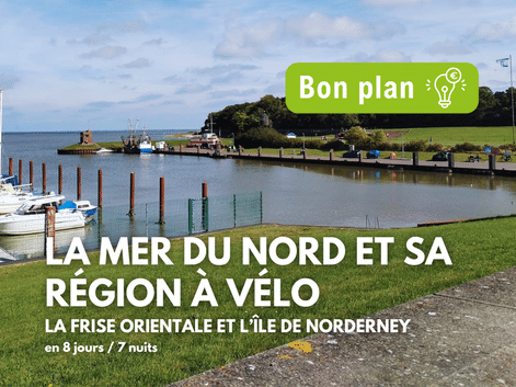 Port de plaisance avec voiliers et pelouse verte sur la côte de la mer du Nord en Allemagne. Texte: La Mer du Nord et sa région à vélo.