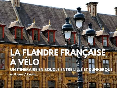 Bâtiment flamand orné avec façade dorée et lucarnes, avec un lampadaire décoratif au premier plan en Flandre française.