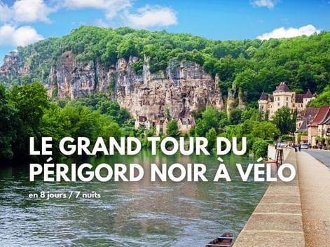 Village pittoresque au bord de la rivière en Périgord avec falaises calcaires, maisons en pierre traditionnelles et rivière calme. Texte: Le Grand Tour du Périgord Noir à Vélo.