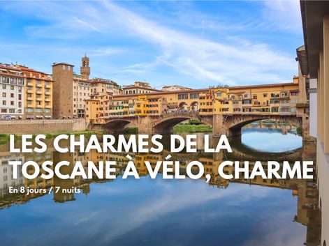 Pont Ponte Vecchio avec bâtiments historiques enjambant l'Arno à Florence, Toscane. Façades colorées se reflétant dans l'eau calme sous ciel bleu.