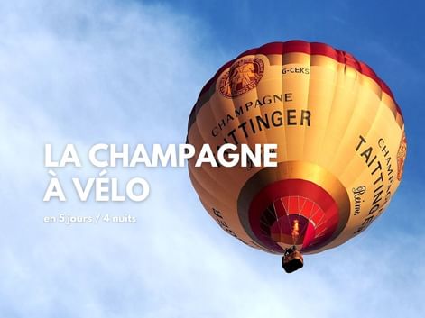 Montgolfière à l'effigie du champagne Taittinger, dans un ciel bleu
