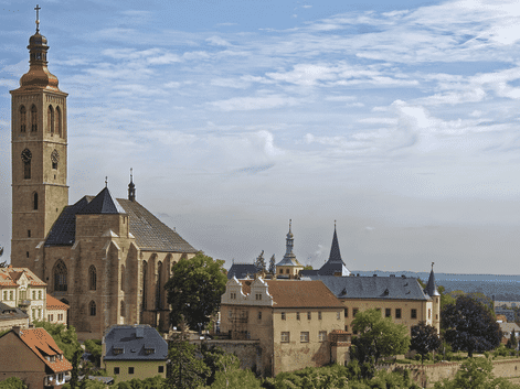 L'église Saint-Jacques avec son haut clocher domine l'horizon historique de Kutná Hora, République tchèque, avec des bâtiments aux toits rouges.