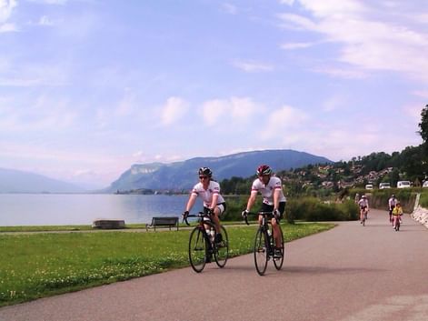 Cyclistes pédalant sur une piste cyclable longeant le Lac Léman
