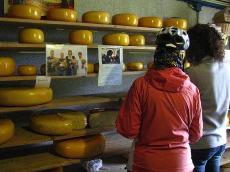 Deux cyclotouristes visitent la boutique d'une fromagerie vendant du Gouda aux Pays-Bas