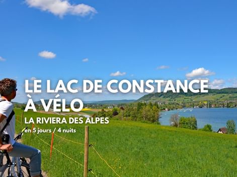 Cycliste arrêté sur la route, admirant le lac de Constance au loin