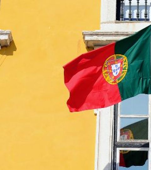 Drapeau portugais flottant sur une façade lisboète